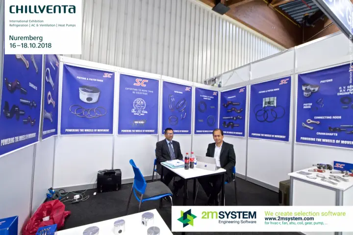 SC team at the table in front of compressor component posters