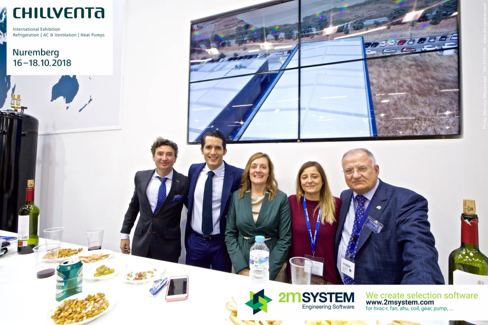 Tecnac team behind the counter with factory footage on screen at Chillventa 2018