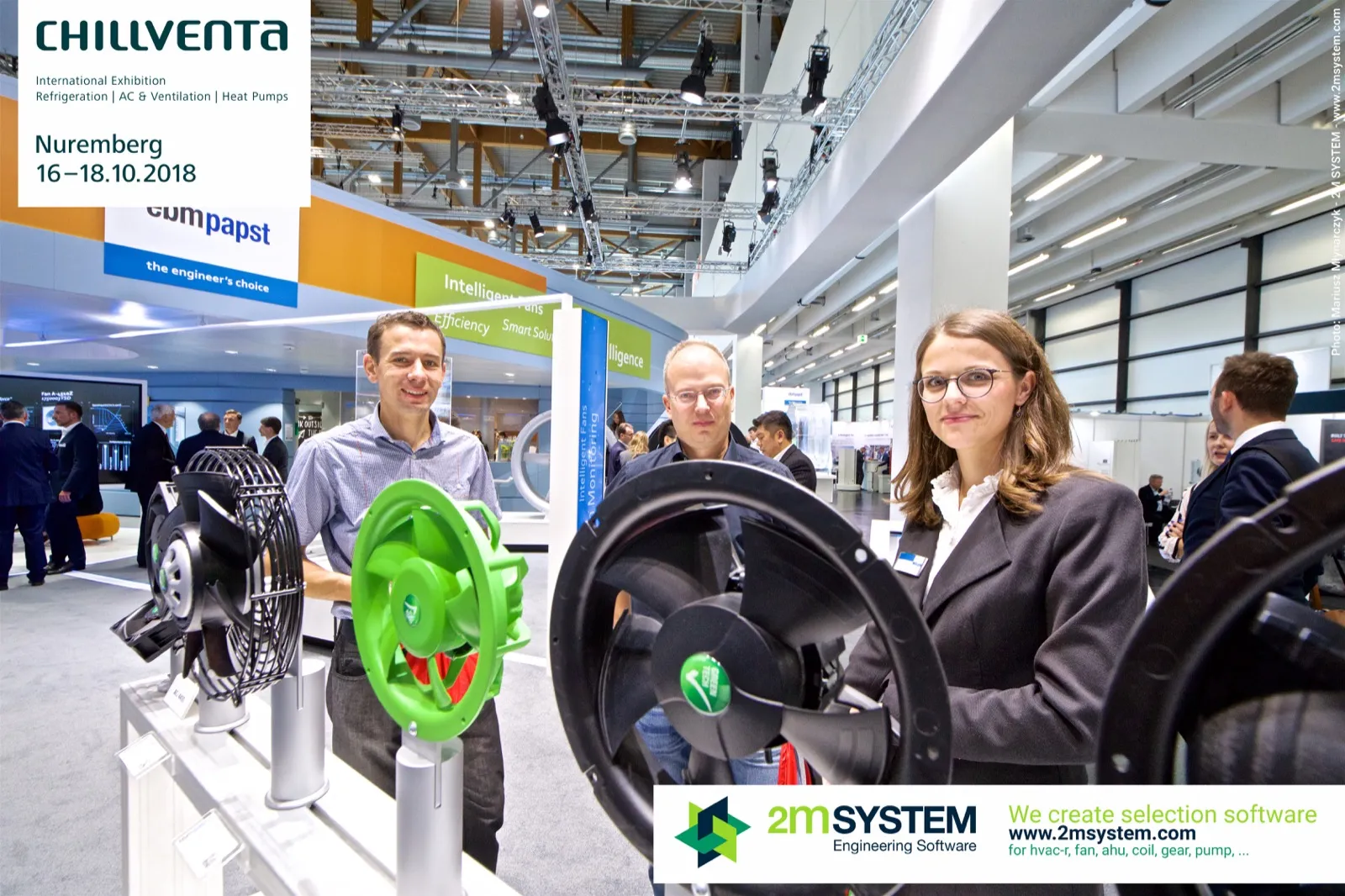 Visitors posing behind green and black ebm-papst axial fans at Chillventa 2018