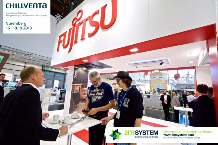Visitors talking at a coffee table under the red Fujitsu logo