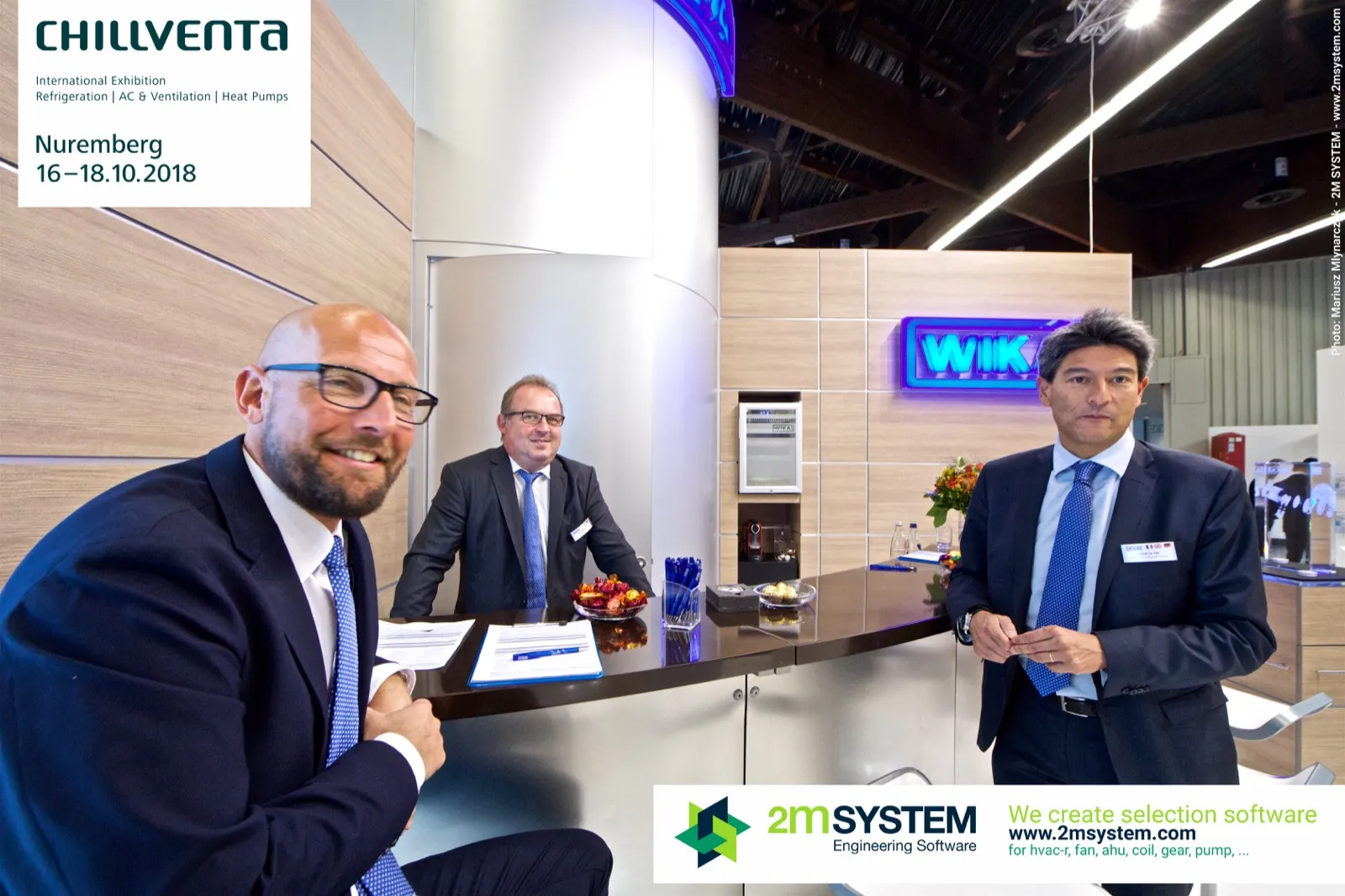 WIKA team at the counter with the blue illuminated logo behind at Chillventa 2018