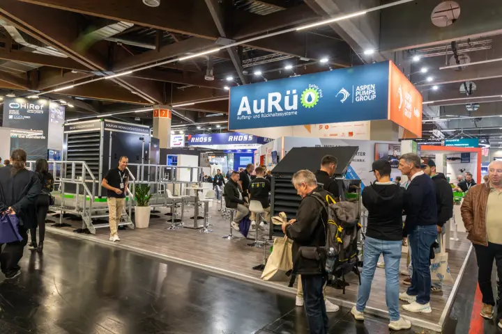 Busy AuRü and Aspen Pumps Group stand with a Solflex noise enclosure
