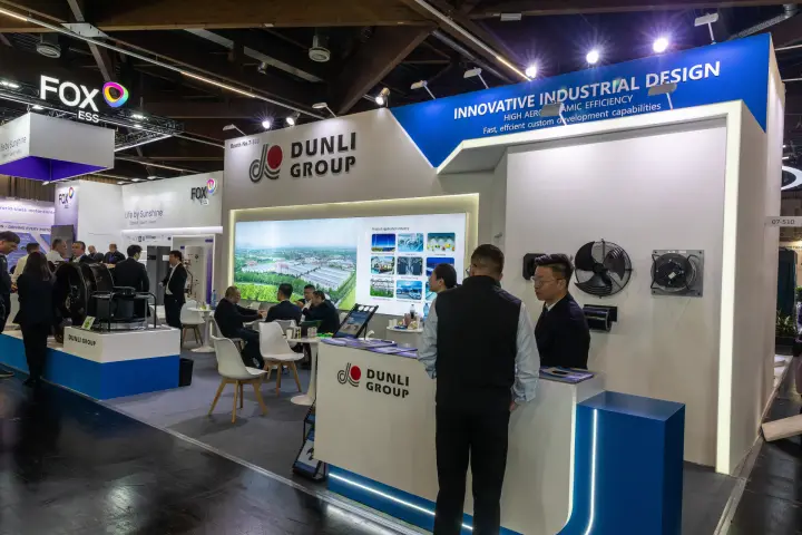 Dunli Group stand overview with meeting tables and fan display wall