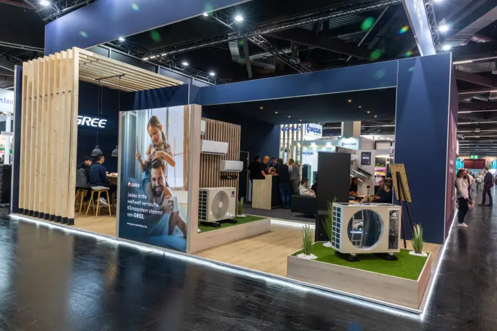 Gree stand with split air conditioners and outdoor units on artificial grass