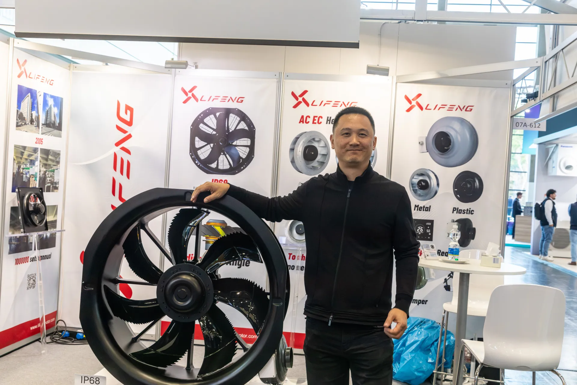 Lifeng exhibitor posing with a sealed IP68 axial fan at Chillventa 2026