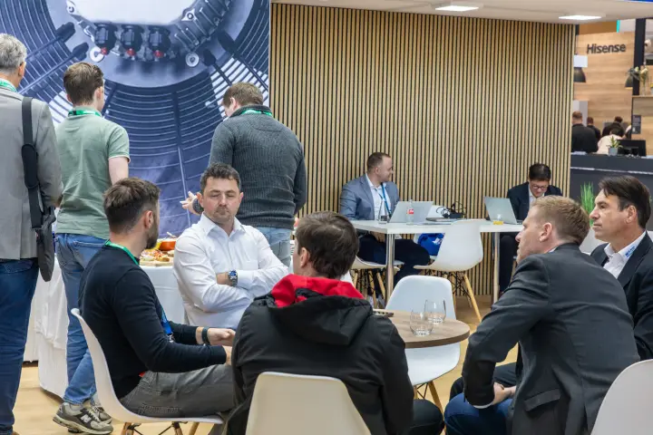 Meeting tables in the Hidria lounge with wooden slatted wall at Chillventa 2026