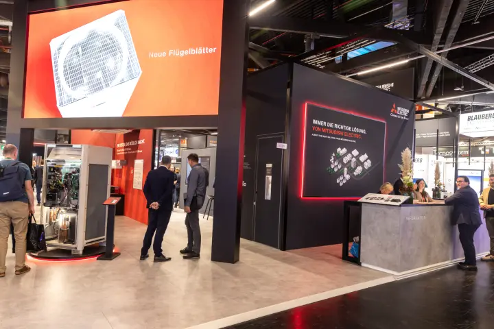 Mitsubishi Electric stand with open outdoor unit and orange LED wall