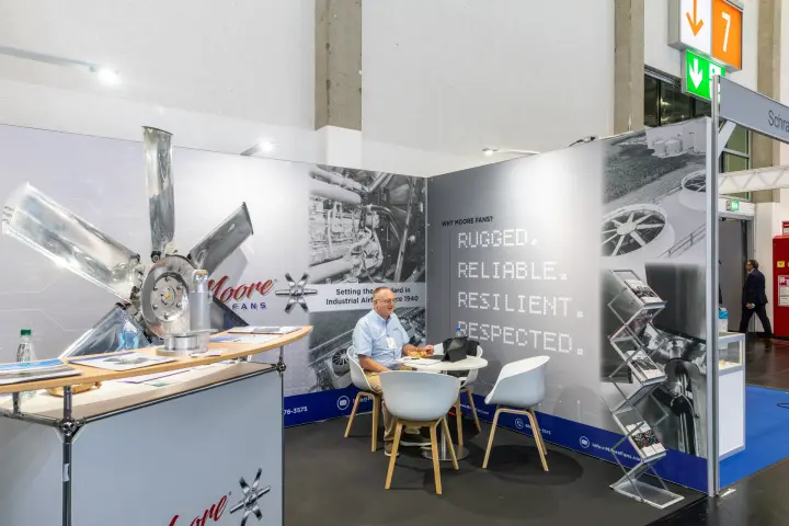 Moore Fans stand with "Rugged. Reliable. Resilient. Respected." wall at Chillventa 2026