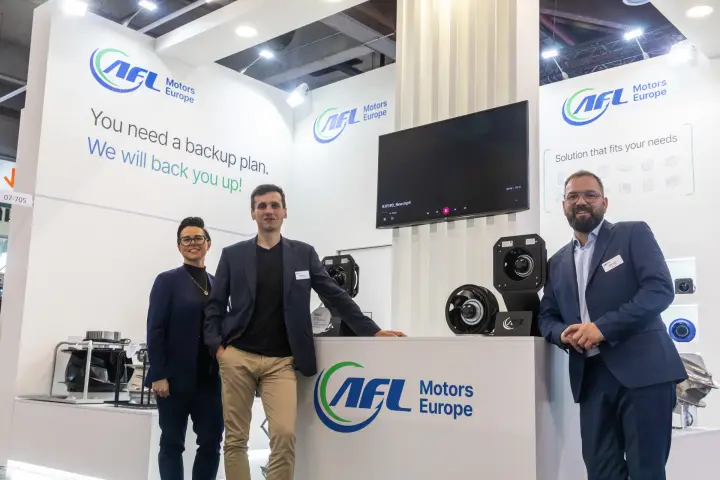 Three AFL Motors Europe staff framing the logo counter