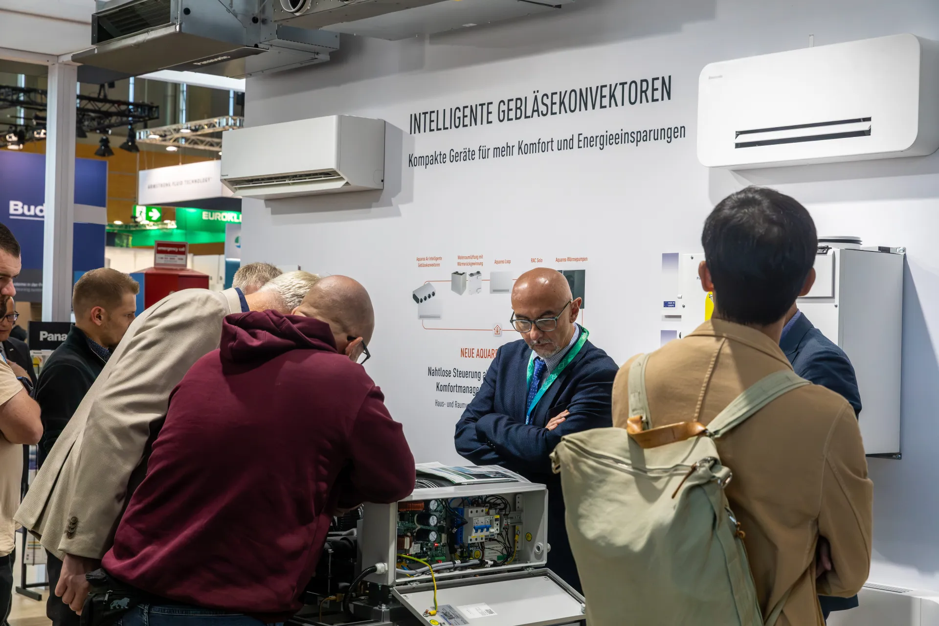 Visitors examining an open Panasonic unit by fan convector display at Chillventa 2026