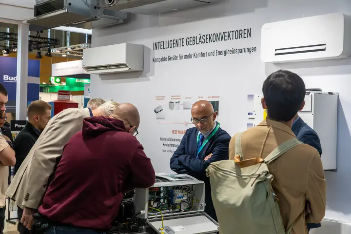 Visitors examining an open Panasonic unit by fan convector display