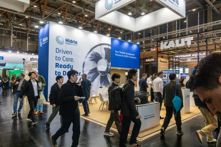 Visitors passing the Hidria stand with its "Driven to Care" fan wall at Chillventa 2026