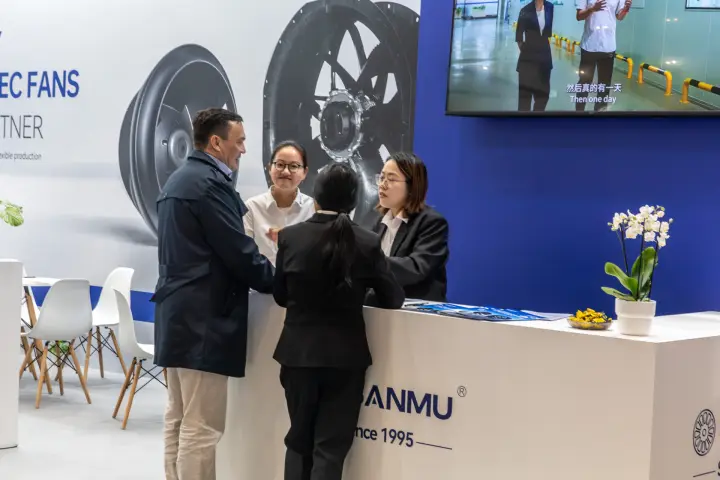 Visitors at the Sanmu reception counter in front of EC fan graphics at Chillventa 2026