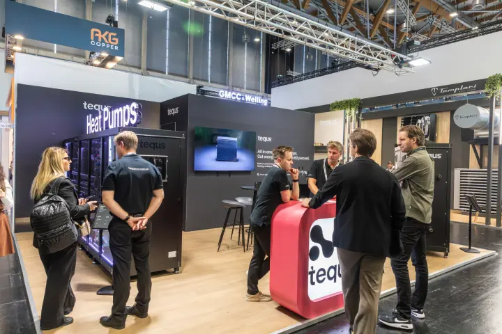 Visitors at the Tequs counter beside glass-fronted CO2 heat pumps at Chillventa 2026