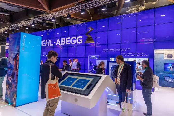 Visitors at a Ziehl-Abegg touchscreen in front of the ECblue Technology display