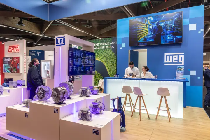 WEG stand with electric motors on lit plinths and "The world asks" slogan at Chillventa 2026