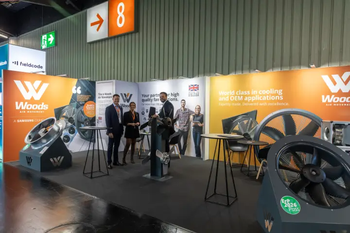 Woods Air Movement team among axial fans on the orange stand at Chillventa 2026