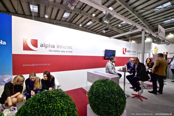Alpha Innotec red and white logo wall with bar tables and seating