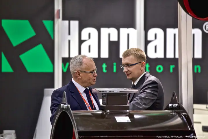 Conversation over a large axial fan below the Harmann Ventilatoren logo at Forum Wentylacja 2016