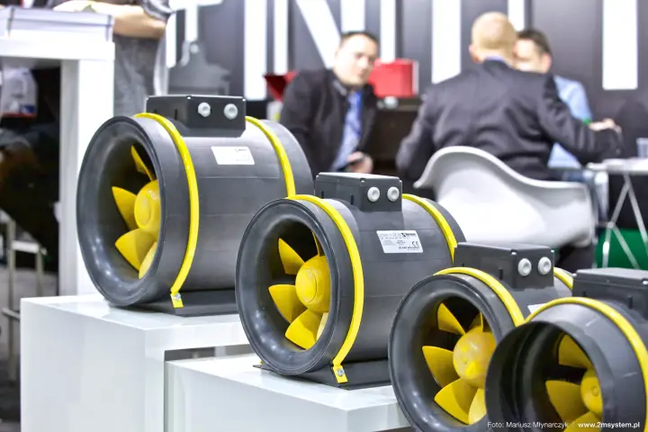 Row of Harmann inline duct fans with yellow impellers and clamps at Forum Wentylacja 2016