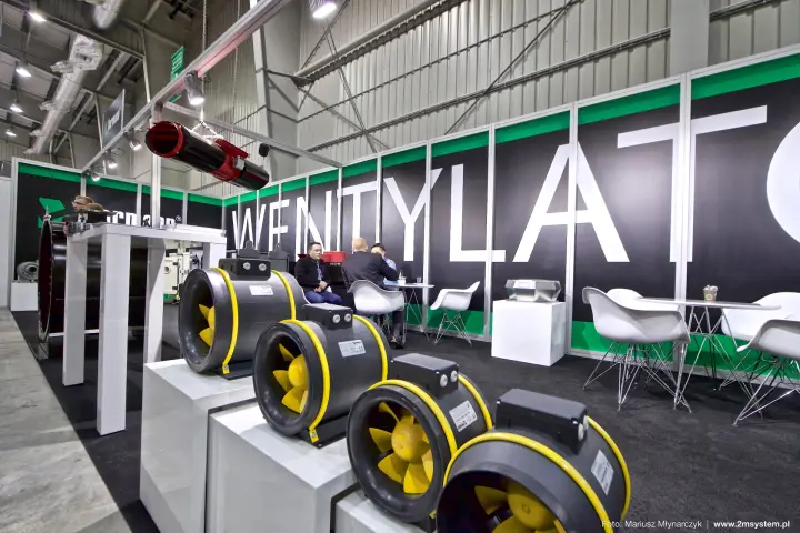 Row of yellow-impeller duct fans on white plinths at the Harmann stand at Forum Wentylacja 2016