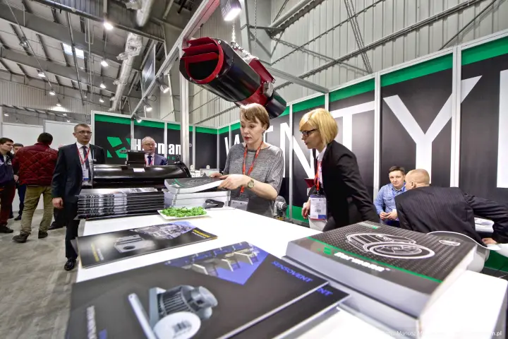 Two staff members arranging catalogues at the Harmann counter at Forum Wentylacja 2016