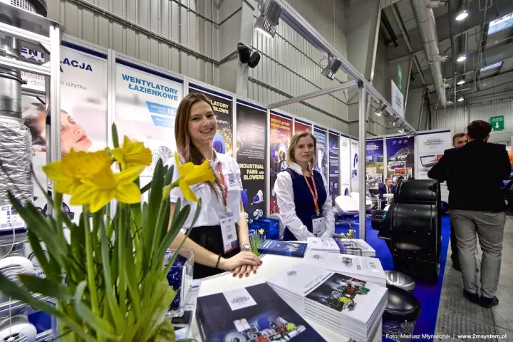 Venture Industries staff at the counter with fan catalogues and daffodils