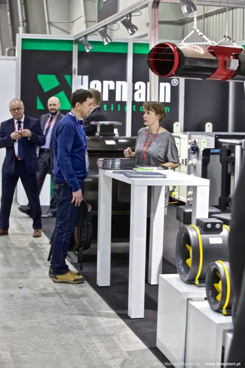 Visitor at the Harmann counter beside inline fans and a hanging jet fan at Forum Wentylacja 2016