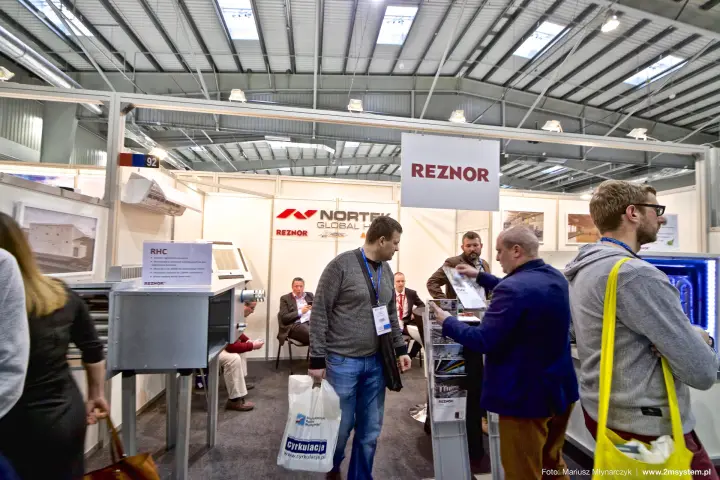 Visitors at the Reznor stand with an RHC warm air heater on display