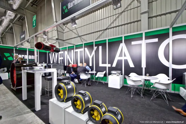 Wide view of the Harmann stand with hanging logo sign and meeting tables at Forum Wentylacja 2016