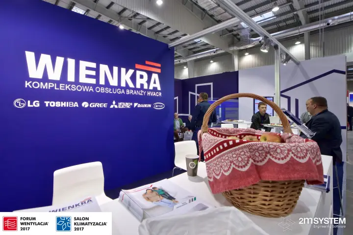 Apple basket on the Wienkra counter in front of the logo wall