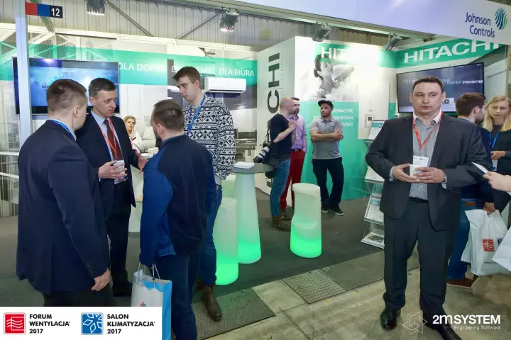 Busy Hitachi stand with glowing bar tables and display screens at Forum Wentylacja 2017