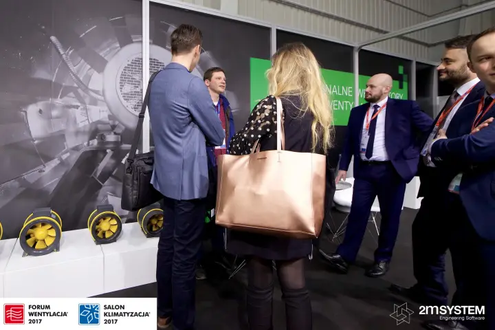 Conversation at the Harmann stand next to yellow inline duct fans at Forum Wentylacja 2017
