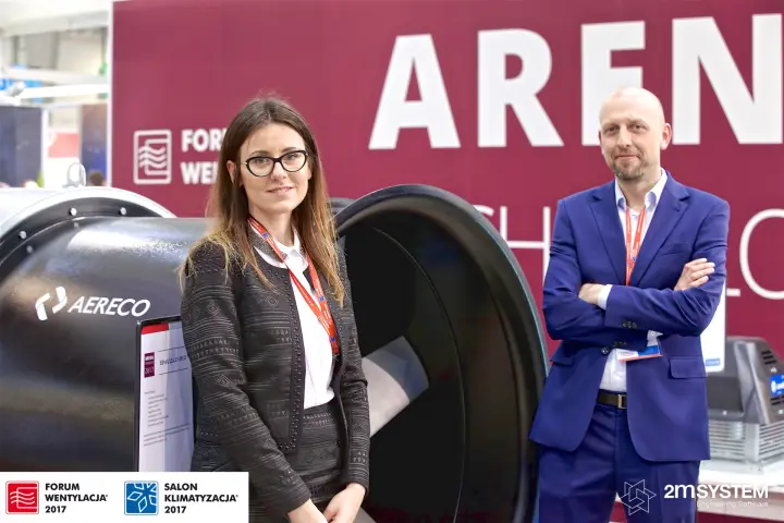 Exhibitors with a black Aereco fan before the Arena backdrop at Forum Wentylacja 2017