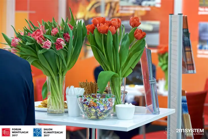 Hospitality table with tulips against orange stand graphics at Forum Wentylacja 2017