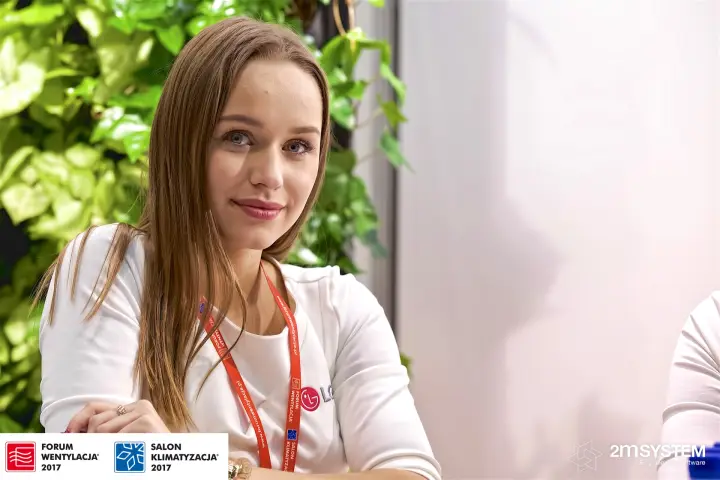 Hostess in an LG-branded top against the HTS stand's green plant wall at Forum Wentylacja 2017