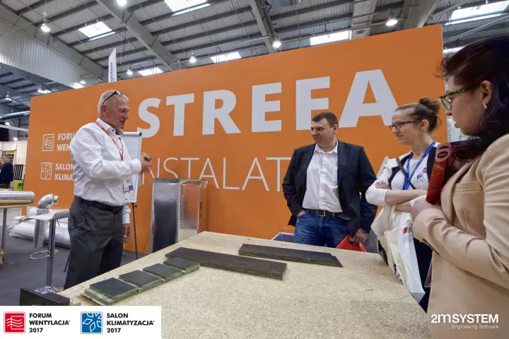 Installer zone talk on duct board samples in front of the Strefa wall