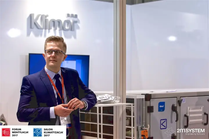 Klimor staff member beside the EVO unit and logo wall