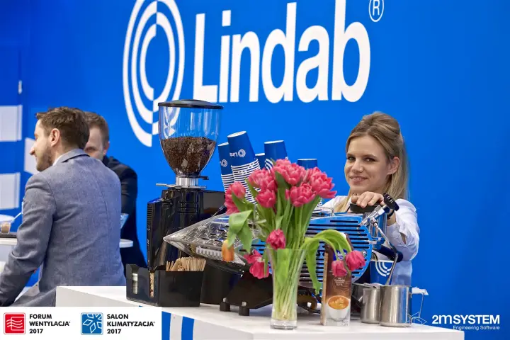Lindab coffee bar under the large logo wall, guests seated nearby