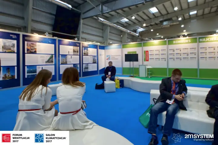 Lounge area with project display panels and a green competition wall at Forum Wentylacja 2017