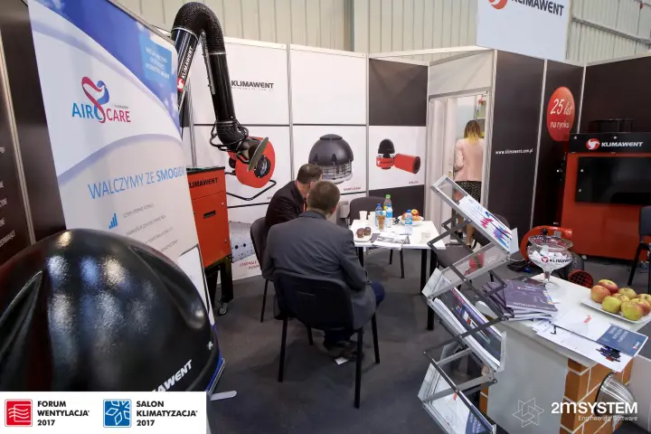 Meeting at the Klimawent stand beside fan product graphics