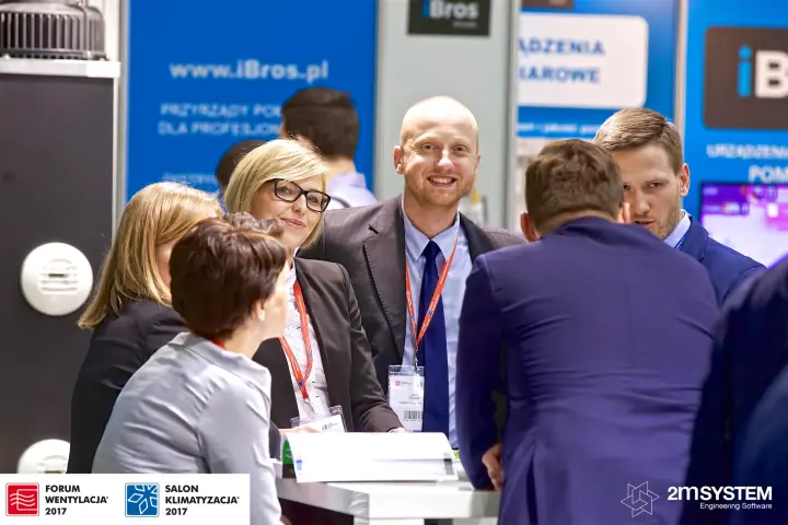 Smiling team members around a catalogue table at Harmann at Forum Wentylacja 2017