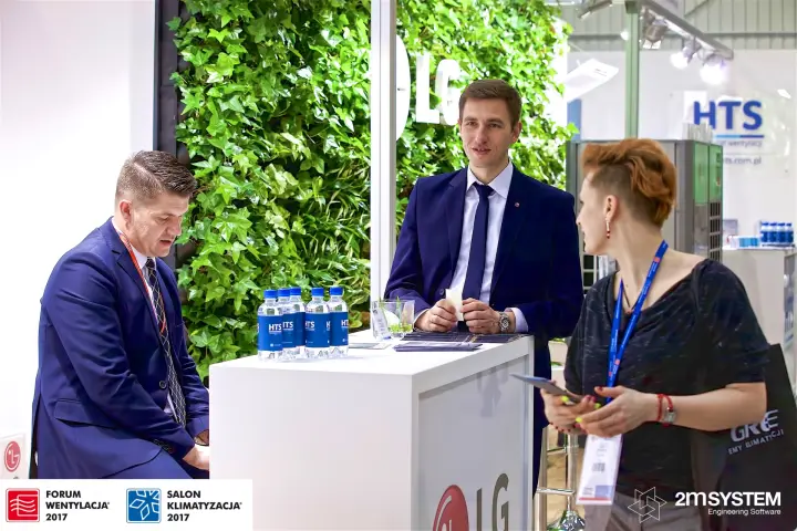 Staff and visitor at the LG counter of the HTS stand with ivy wall at Forum Wentylacja 2017