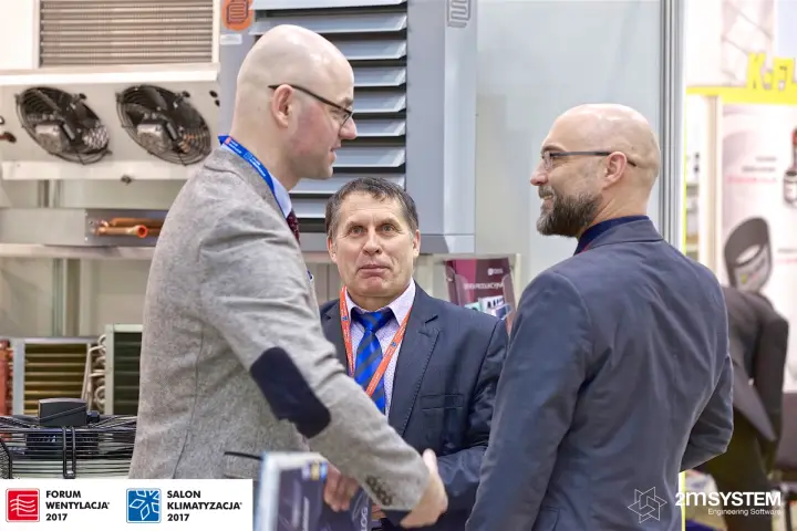 Three visitors in conversation among PPUCh Tarczyn coolers and heaters at Forum Wentylacja 2017