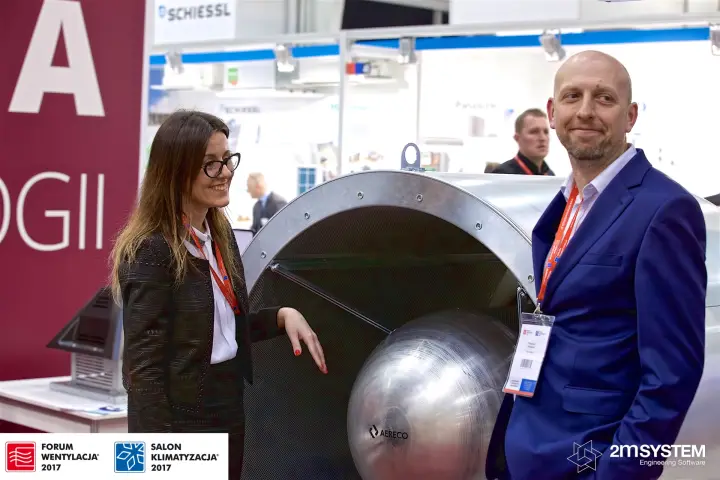 Two visitors beside a large Aereco fan in the Arena area at Forum Wentylacja 2017