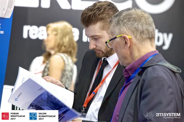 Two visitors leafing through Aereco product literature at Forum Wentylacja 2017