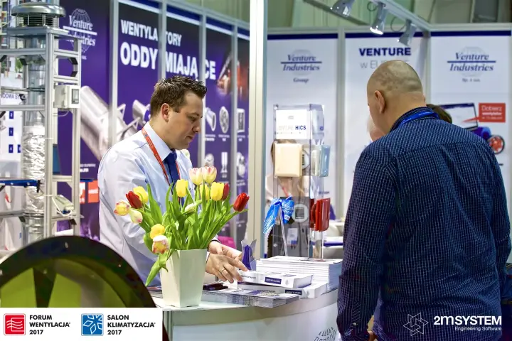 Venture Industries representative hands out fan catalogues to a visitor