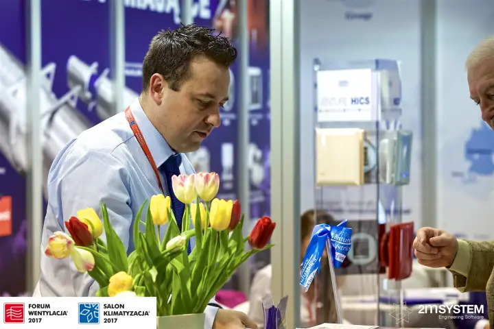 Venture Industries staff at the counter with tulips and a Venture HICS display at Forum Wentylacja 2017