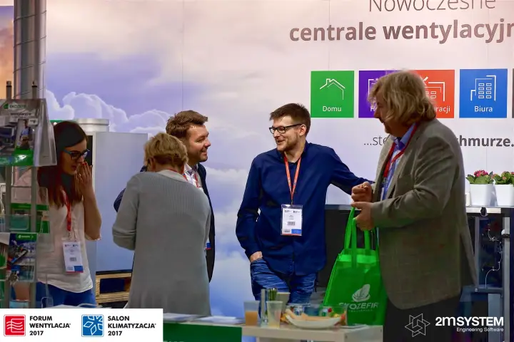 Visitors chatting at the EkoZefir stand with green branded bags at Forum Wentylacja 2017