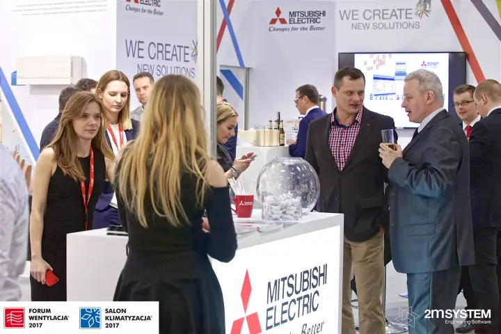Visitors with drinks at the Mitsubishi Electric counter and screen at Forum Wentylacja 2017